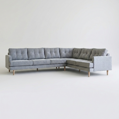 A modern L-shaped sectional sofa upholstered in light gray fabric with tufted back cushions and light wood legs